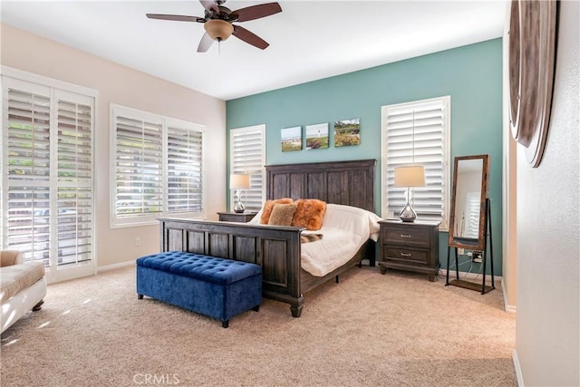 bedroom featuring ceiling fan, baseboards, and light colored carpet