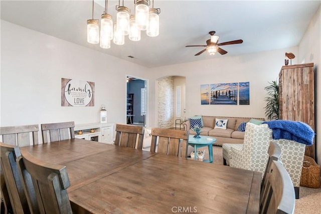 dining room with arched walkways and ceiling fan