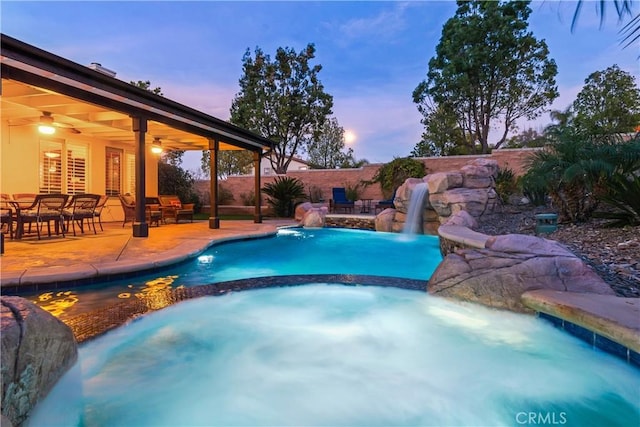 view of pool featuring a patio area, a fenced backyard, a pool with connected hot tub, and a ceiling fan