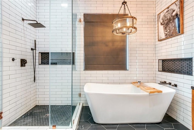 full bathroom with a freestanding bath, a stall shower, tile walls, and tile patterned floors