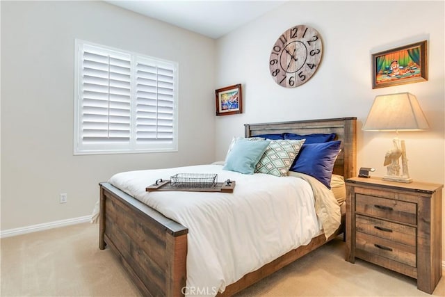 bedroom with light carpet and baseboards