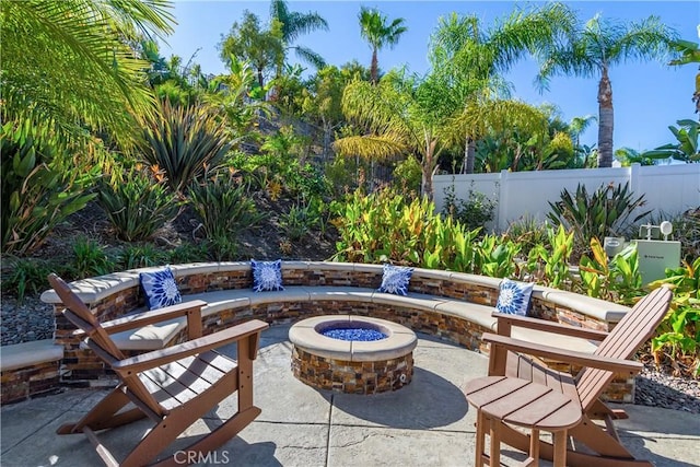 view of patio with an outdoor fire pit and fence