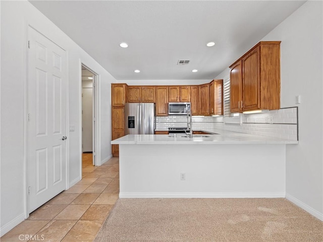 11175 Avonlea Rd, Apple Valley, CA 92308 - kitchen featuring stainless steel appliances, light countertops, a peninsula, recessed lighting, and brown cabinets