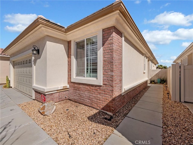 11175 Avonlea Rd, Apple Valley, CA 92308 - view of home's exterior featuring an attached garage, driveway, stucco siding, and brick siding
