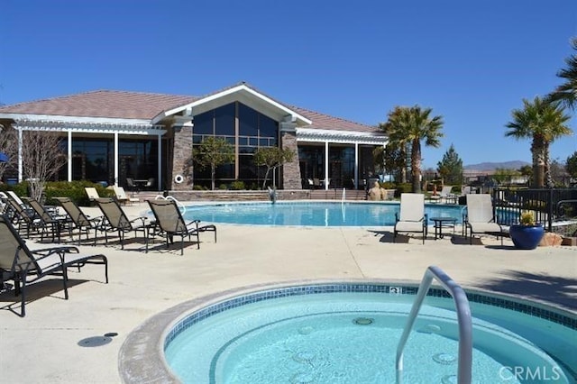 view of swimming pool with a patio area and a hot tub