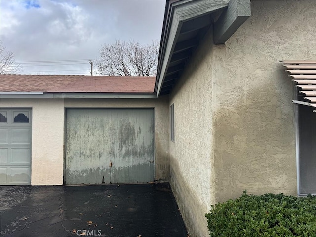 view of property exterior with a shingled roof and stucco siding