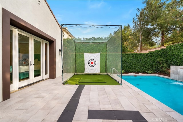 view of pool with a patio area, french doors, and pool water feature