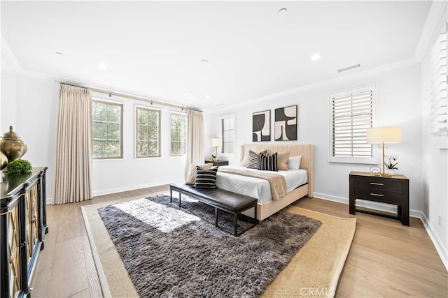 bedroom featuring light wood-type flooring and ornamental molding