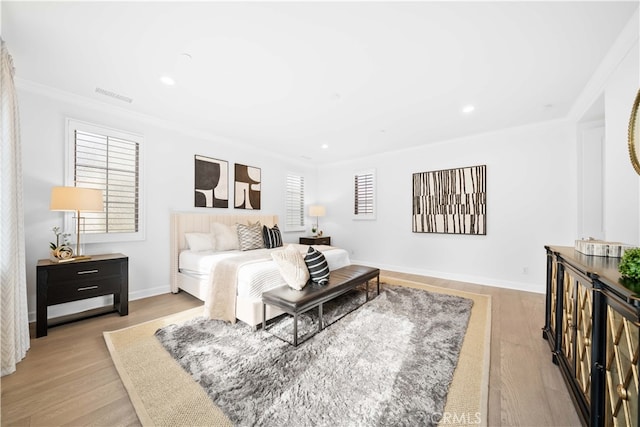 bedroom with light hardwood / wood-style floors and ornamental molding