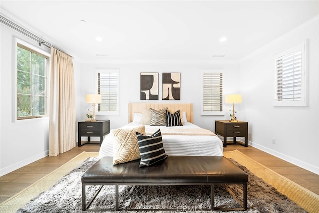 bedroom featuring light wood-type flooring and crown molding