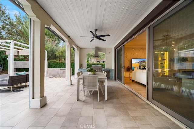 sunroom featuring ceiling fan and wooden ceiling