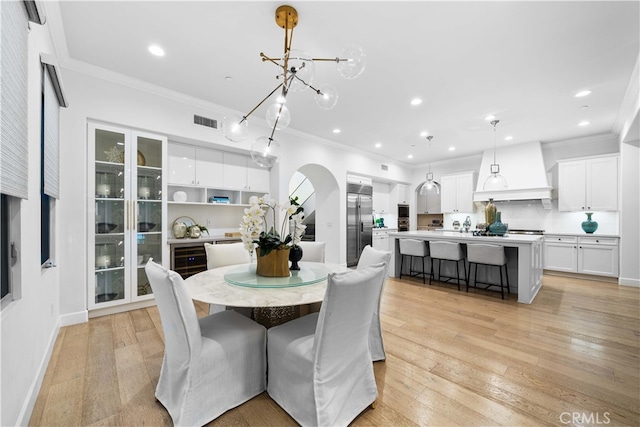 dining space with crown molding and light hardwood / wood-style floors