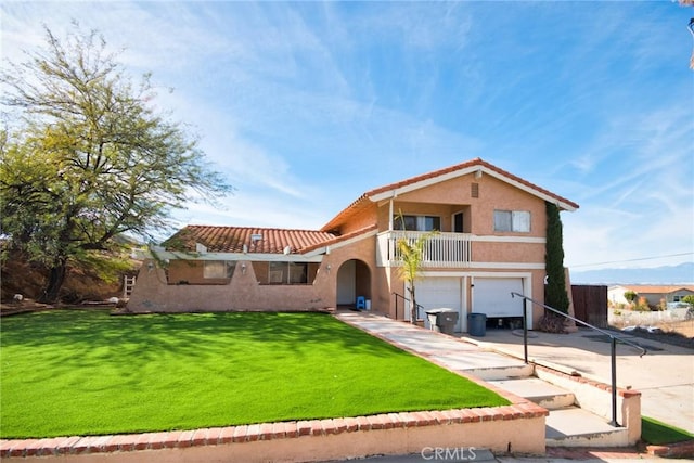 mediterranean / spanish-style home featuring a front lawn, a garage, and a balcony