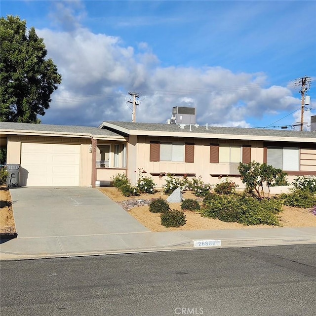 ranch-style home with a garage and central AC