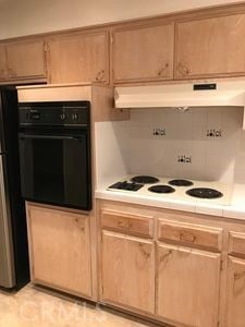 kitchen featuring white stovetop and black oven