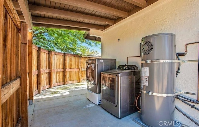 laundry room featuring water heater, washing machine and dryer, and wooden ceiling