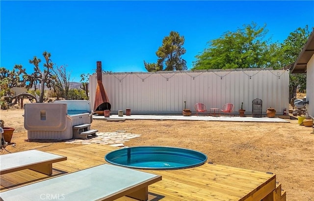 exterior space featuring a covered hot tub and a deck