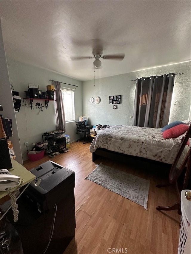 bedroom featuring ceiling fan, a textured ceiling, and light hardwood / wood-style floors