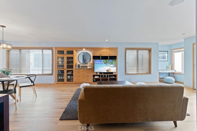 living room featuring a notable chandelier and light hardwood / wood-style flooring