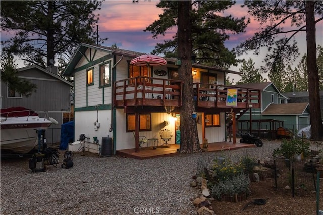 back house at dusk featuring central AC and a deck