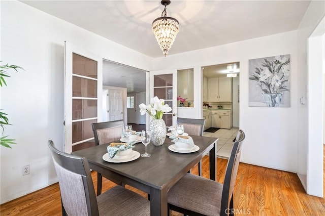 dining area featuring a notable chandelier and light wood-style floors