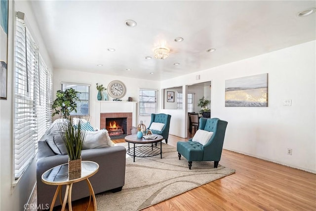 living area with a fireplace, wood finished floors, and recessed lighting