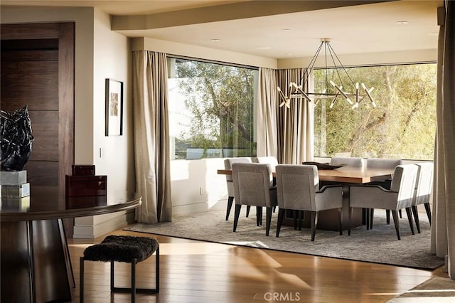 dining area featuring wood-type flooring and a chandelier