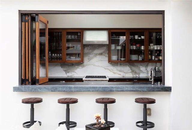 bar with stove, sink, and backsplash