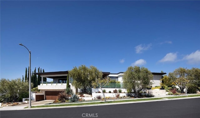 view of front of property featuring a garage and a balcony