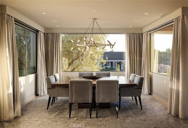 carpeted dining area with a chandelier