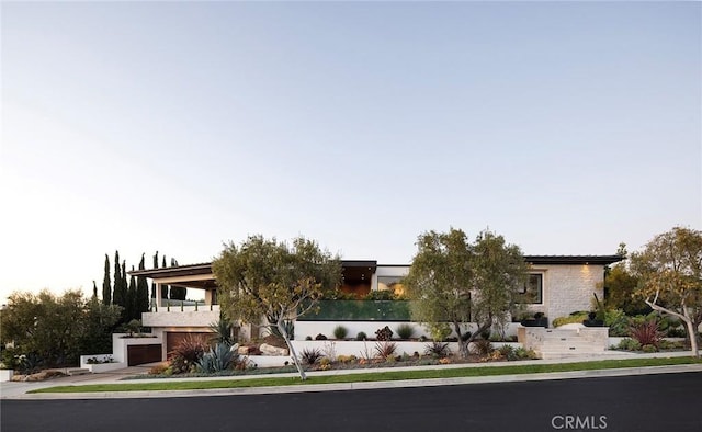 view of front of home with a garage and a balcony