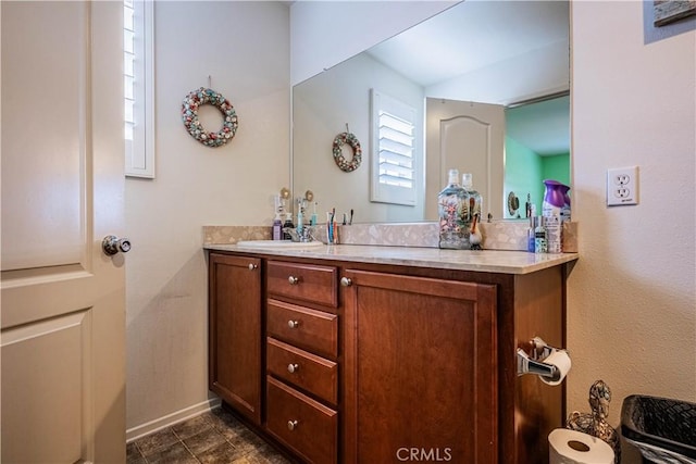 bathroom with tile patterned flooring, baseboards, and vanity