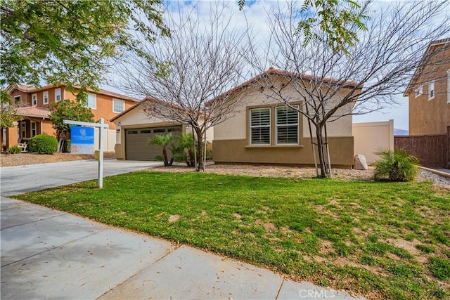 view of front facade with a front yard, fence, concrete driveway, and stucco siding