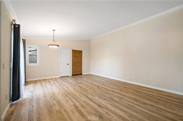 empty room featuring crown molding and light hardwood / wood-style flooring