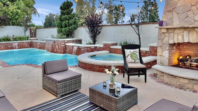 view of pool featuring a patio, a fenced in pool, an in ground hot tub, a fenced backyard, and an outdoor stone fireplace