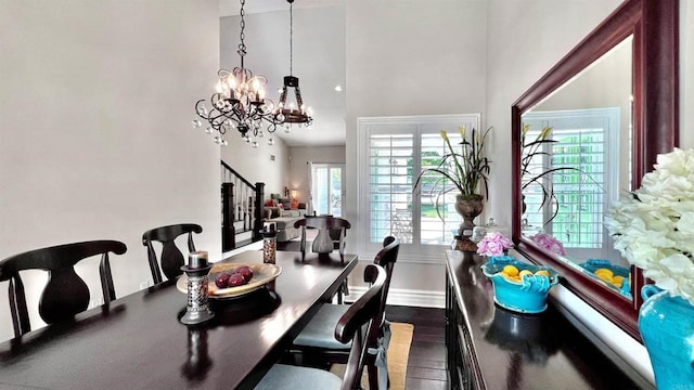 41 Baroness Ln, Laguna Niguel, CA 92677 - dining area featuring a towering ceiling, stairway, a chandelier, dark wood-style floors, and baseboards