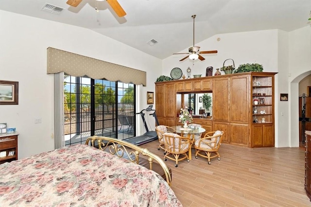 bedroom featuring stainless steel fridge, high vaulted ceiling, light hardwood / wood-style flooring, and access to outside