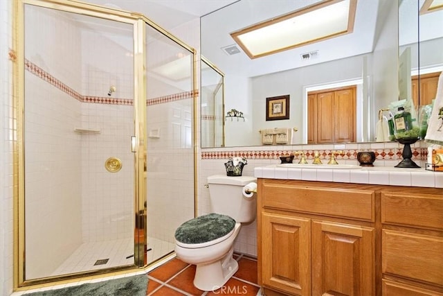 bathroom featuring a shower with shower door, tile walls, vanity, toilet, and tile patterned floors