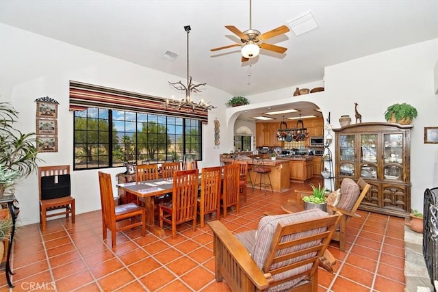 tiled dining room featuring ceiling fan with notable chandelier