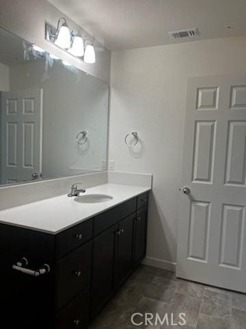 bathroom with visible vents, vanity, and baseboards