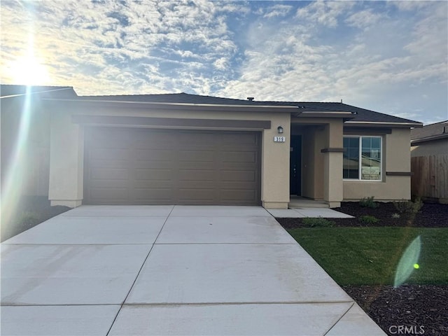 view of front of home featuring driveway, an attached garage, and stucco siding