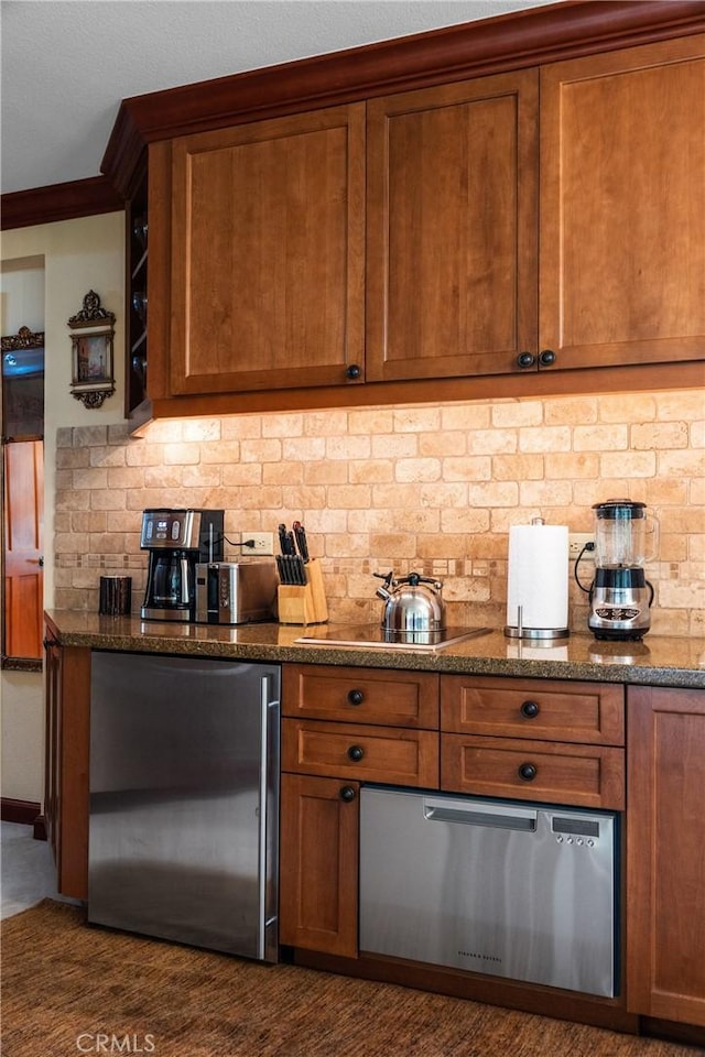 bar featuring dark stone countertops, decorative backsplash, black electric cooktop, and stainless steel refrigerator