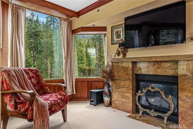 living area with ornamental molding, light carpet, and a fireplace