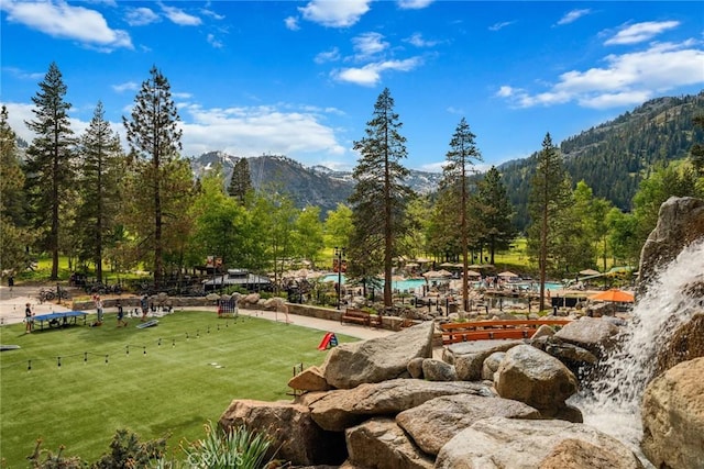 view of community featuring a mountain view and a yard