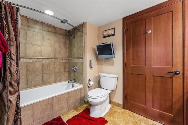 bathroom featuring shower / tub combo and toilet