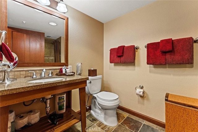 bathroom featuring tasteful backsplash, sink, and toilet