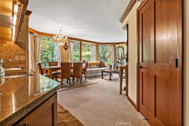 dining area featuring an inviting chandelier, a healthy amount of sunlight, sink, and light carpet