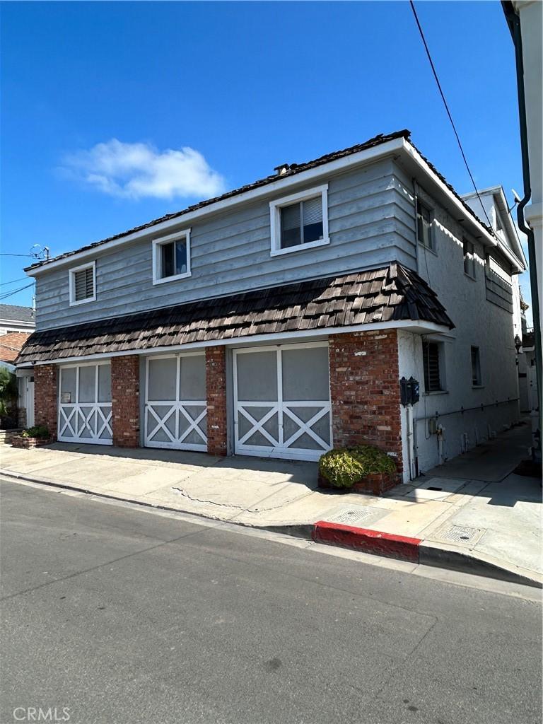 traditional-style house with a garage, driveway, and brick siding