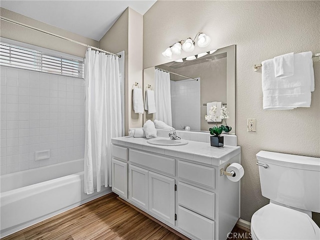 full bath featuring shower / bathtub combination with curtain, toilet, wood finished floors, vanity, and a textured wall