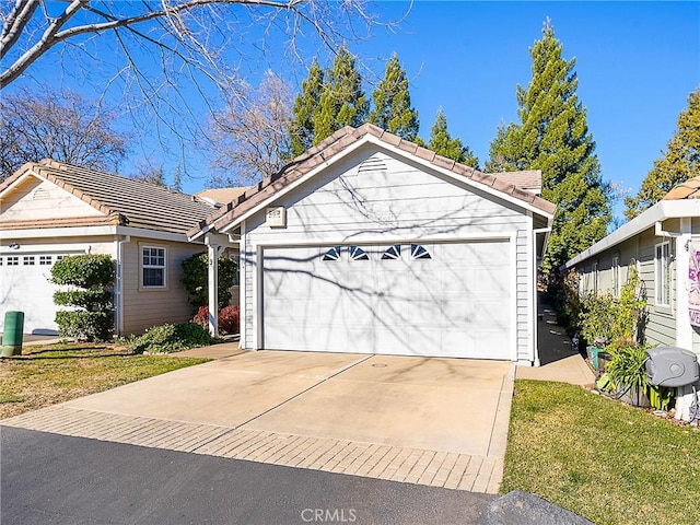 ranch-style house with a tile roof and a garage